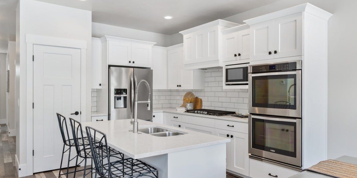 A white kitchen with island seating