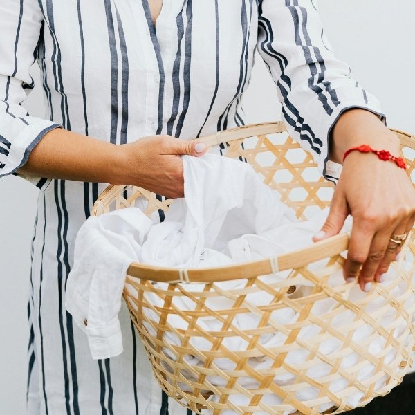 A person holding a basket of fresh laundry
