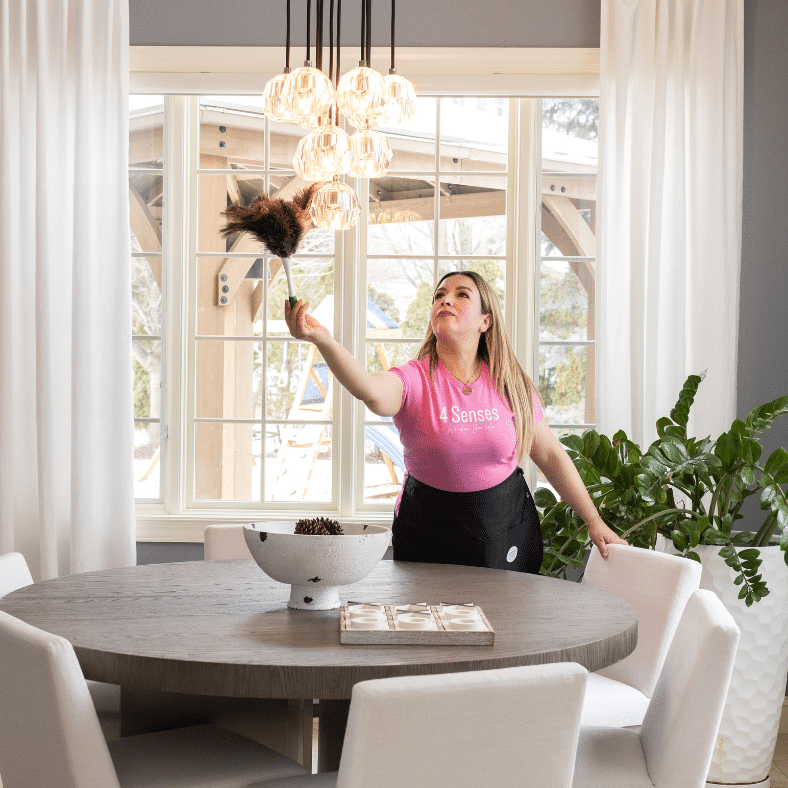 A 4 Senses technician dusting a dining room